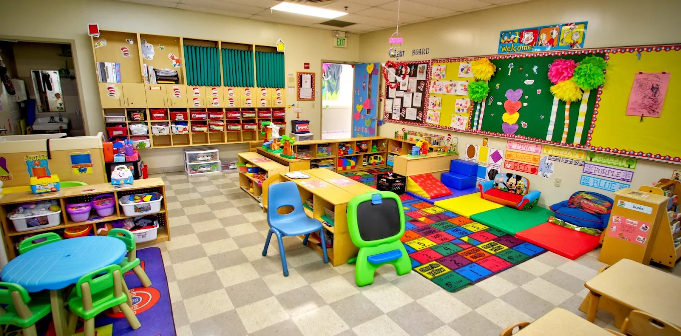 A bright, colorful classroom with a rug and small tables